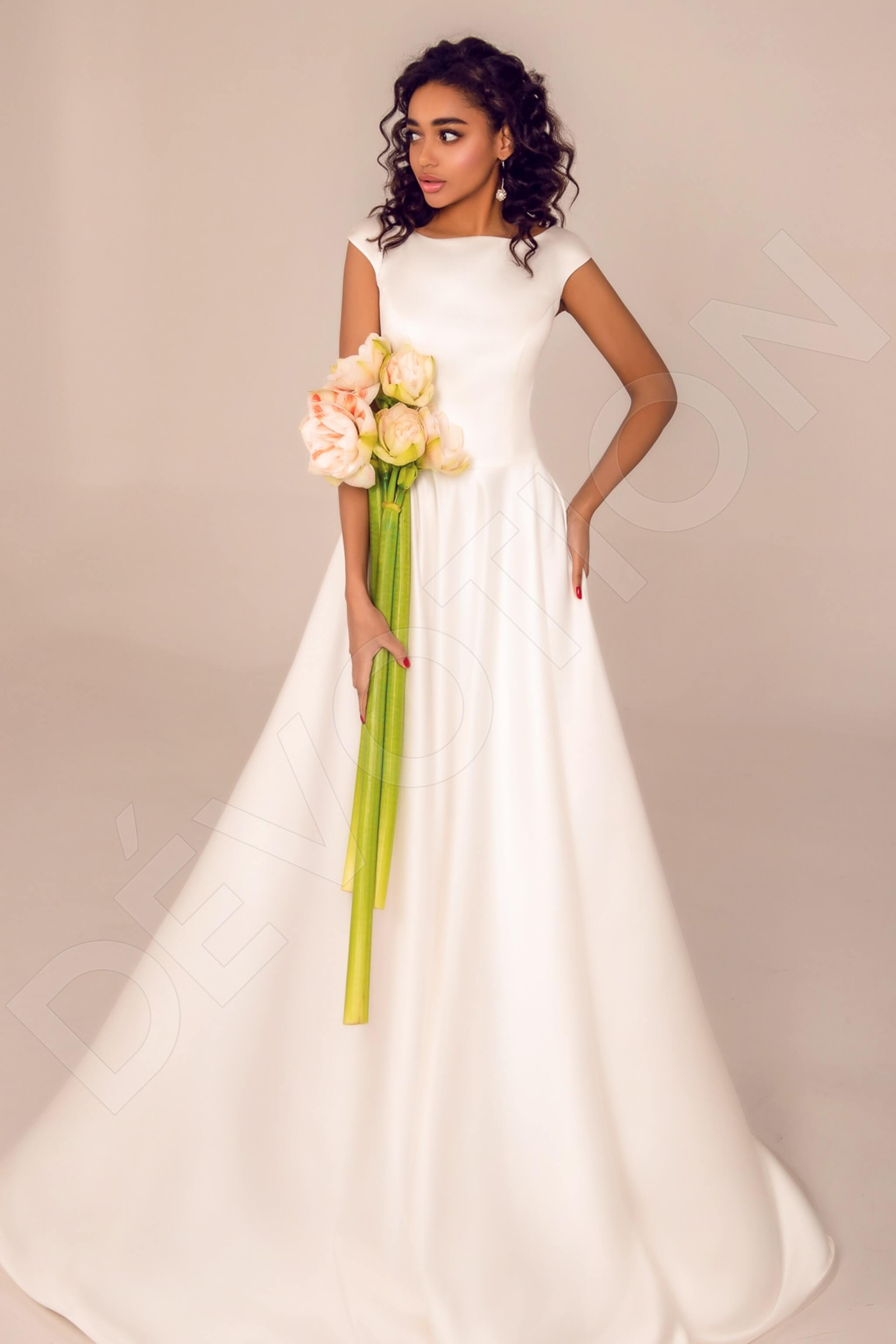 A bride in a flowing A-line boat neck white wedding dress, exuding timeless elegance.