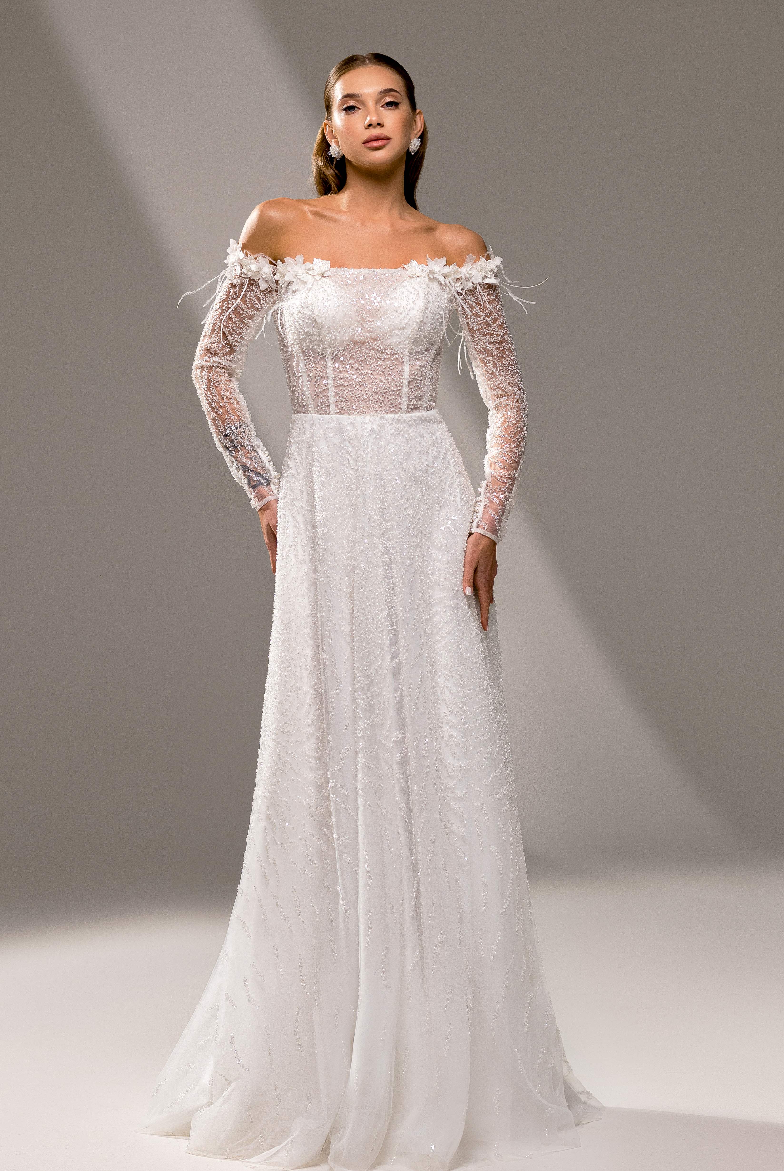 A bride in an elegant A-line off-shoulder wedding dress, perfect for a destination wedding or a romantic evening